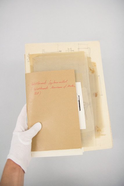 Eine Hand, die eine Mappe mit verschiedenem Papier hälft