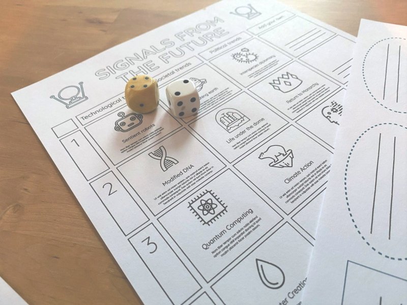 Photo of printed out boardgame materials and dice